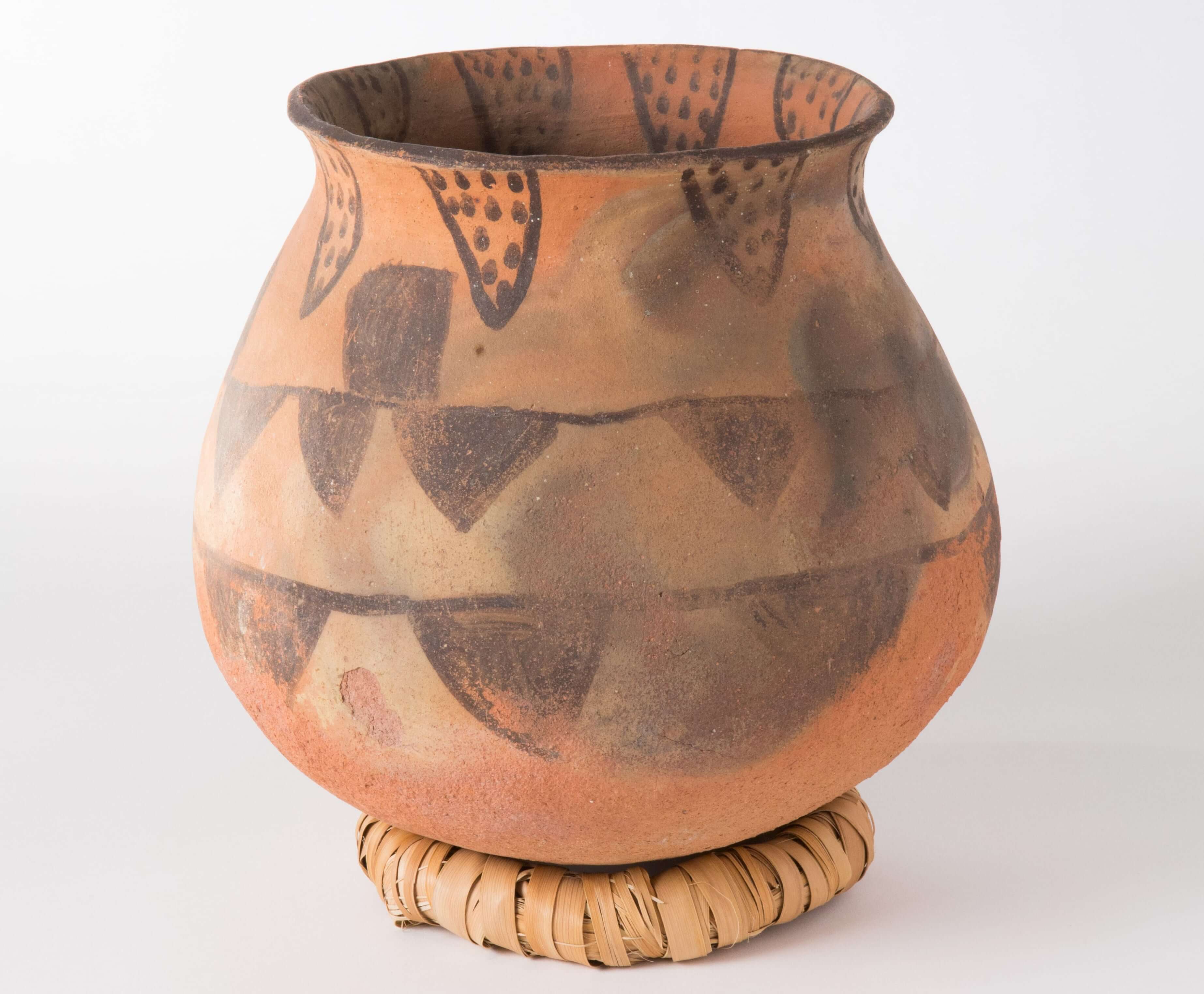 A traditional Cahuilla pottery vessel, called an olla, featuring a black triangular design.
